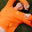 Person wearing an orange sweater lying on grass