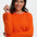Woman wearing an orange sweater with a white background