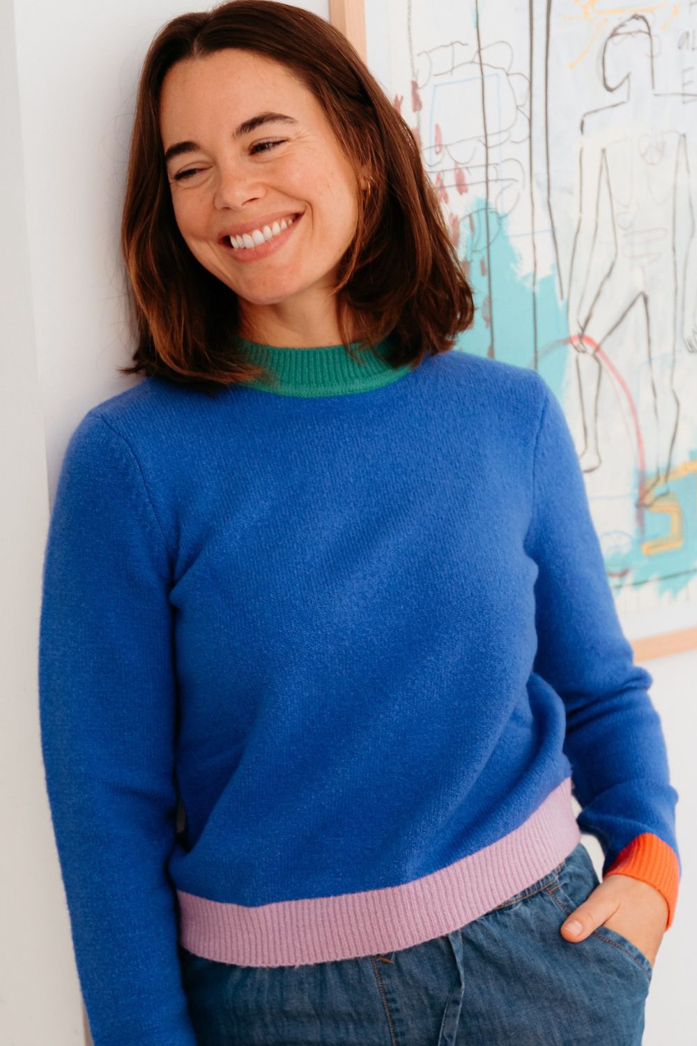 Woman wearing a blue sweater with a colorful background