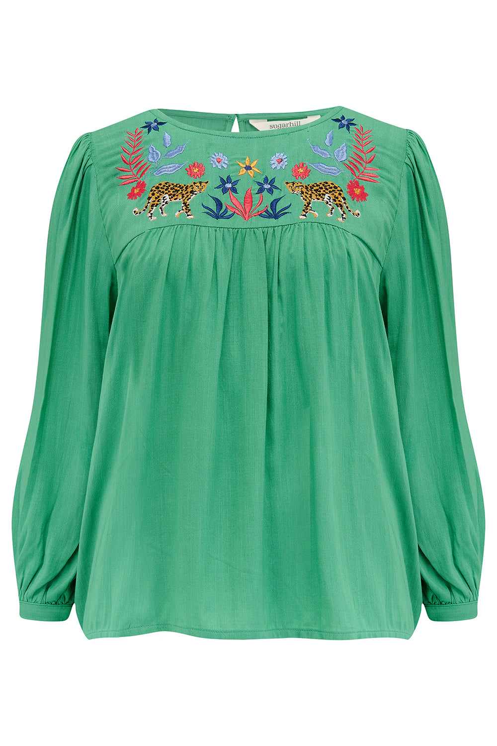 A green top with leopard floral embroidery, featuring a relaxed fit with blouson sleeves and gathered detailing, paired with jeans.