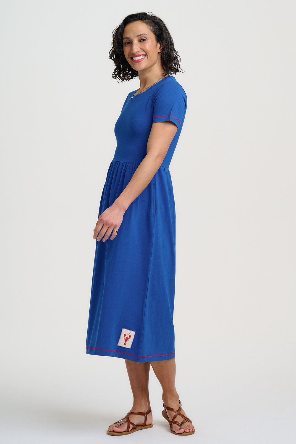 Woman wearing a blue dress with a logo on a white background