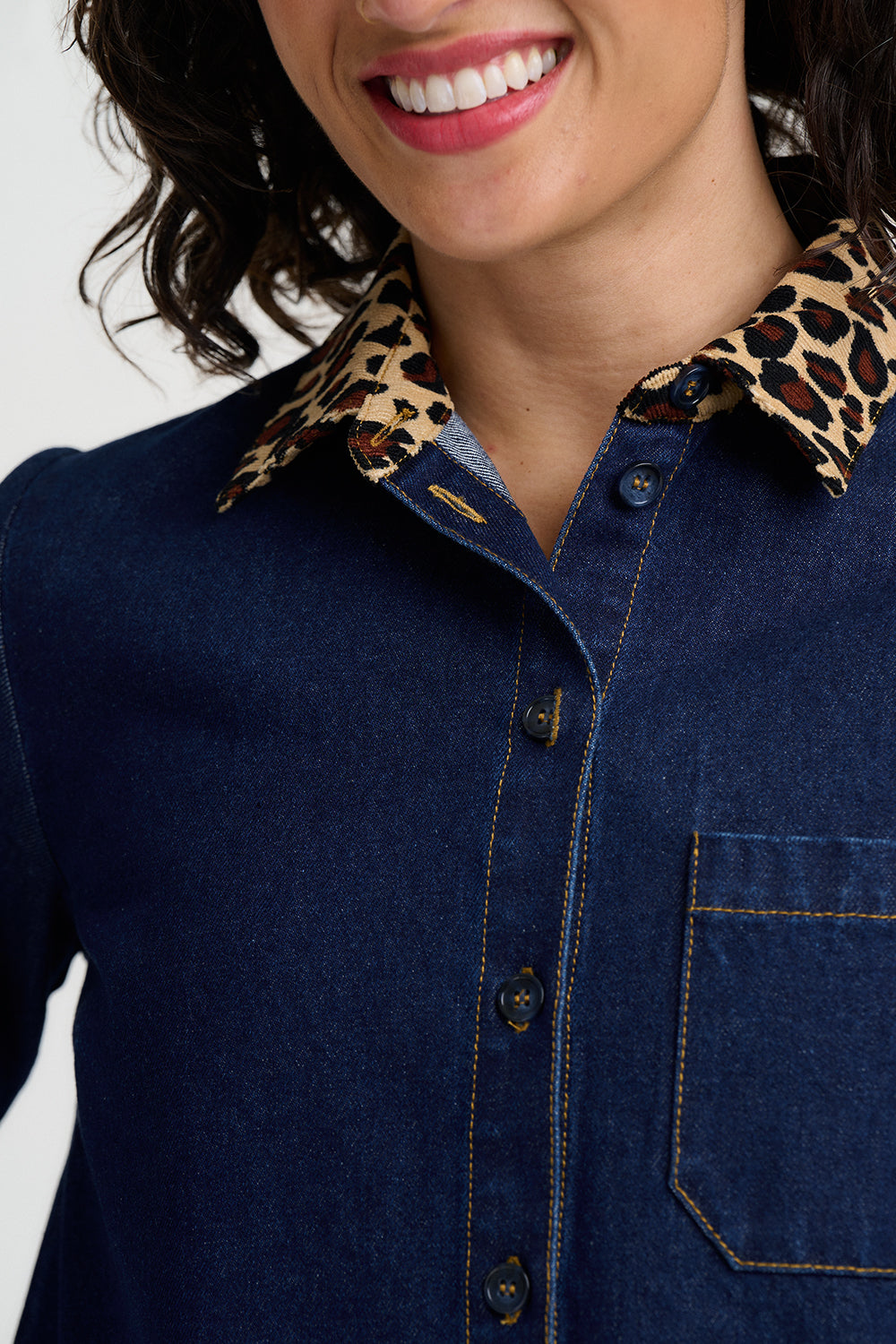 Navy blue denim shirt with leopard print collar worn by a person.