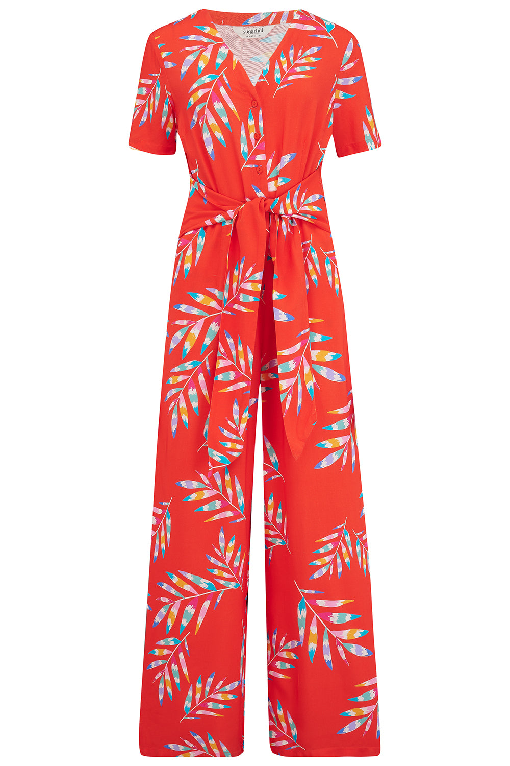 A red jumpsuit with a rainbow frond pattern, featuring a round neckline and a tie-waist belt.