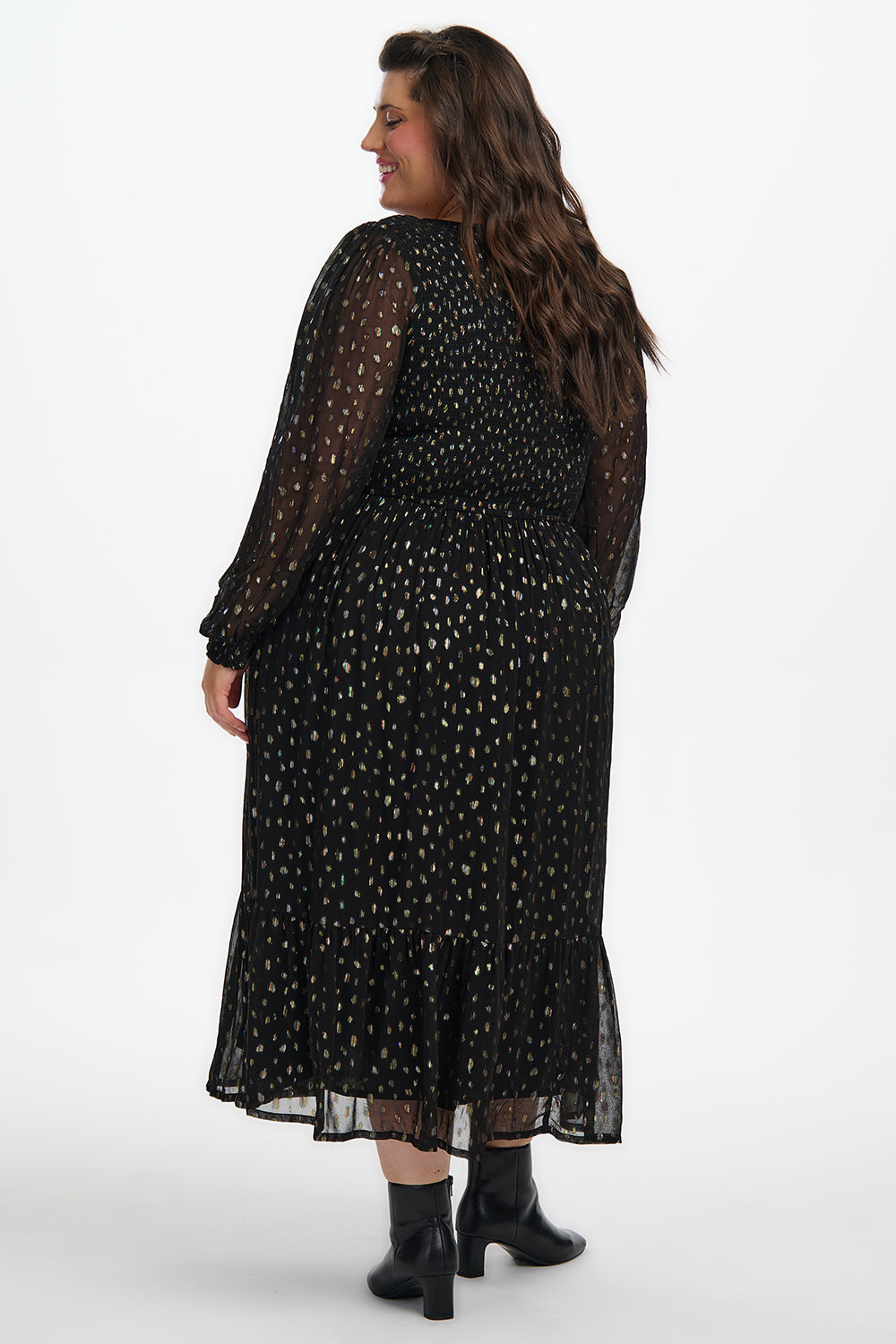 Woman wearing a black polka dot dress on a white background