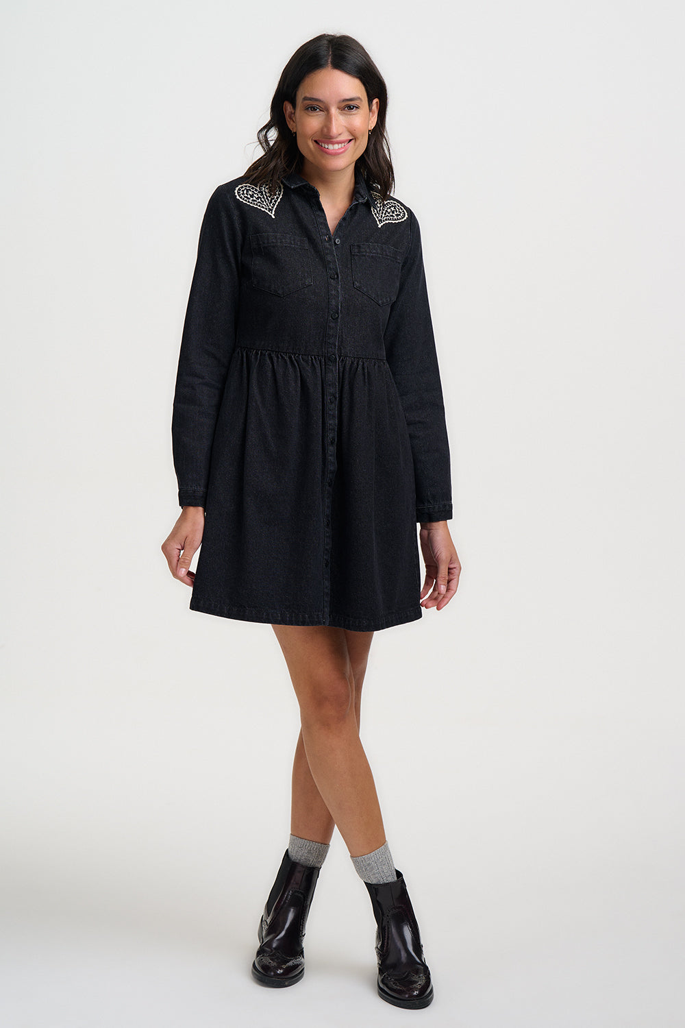 Woman wearing a black dress with white patterns on a white background