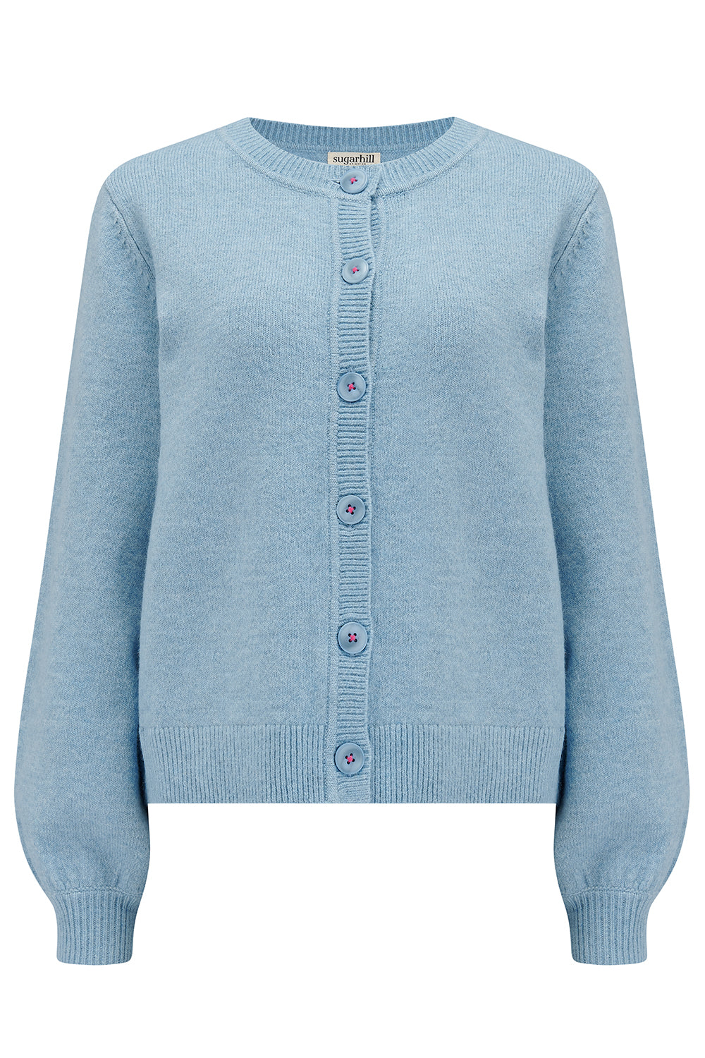 A sky blue Jamie Cardigan with ribbed round neck, buttoned front, and blouson sleeve. The cardigan features small matching sky blue buttons with accent hot pink stitching.