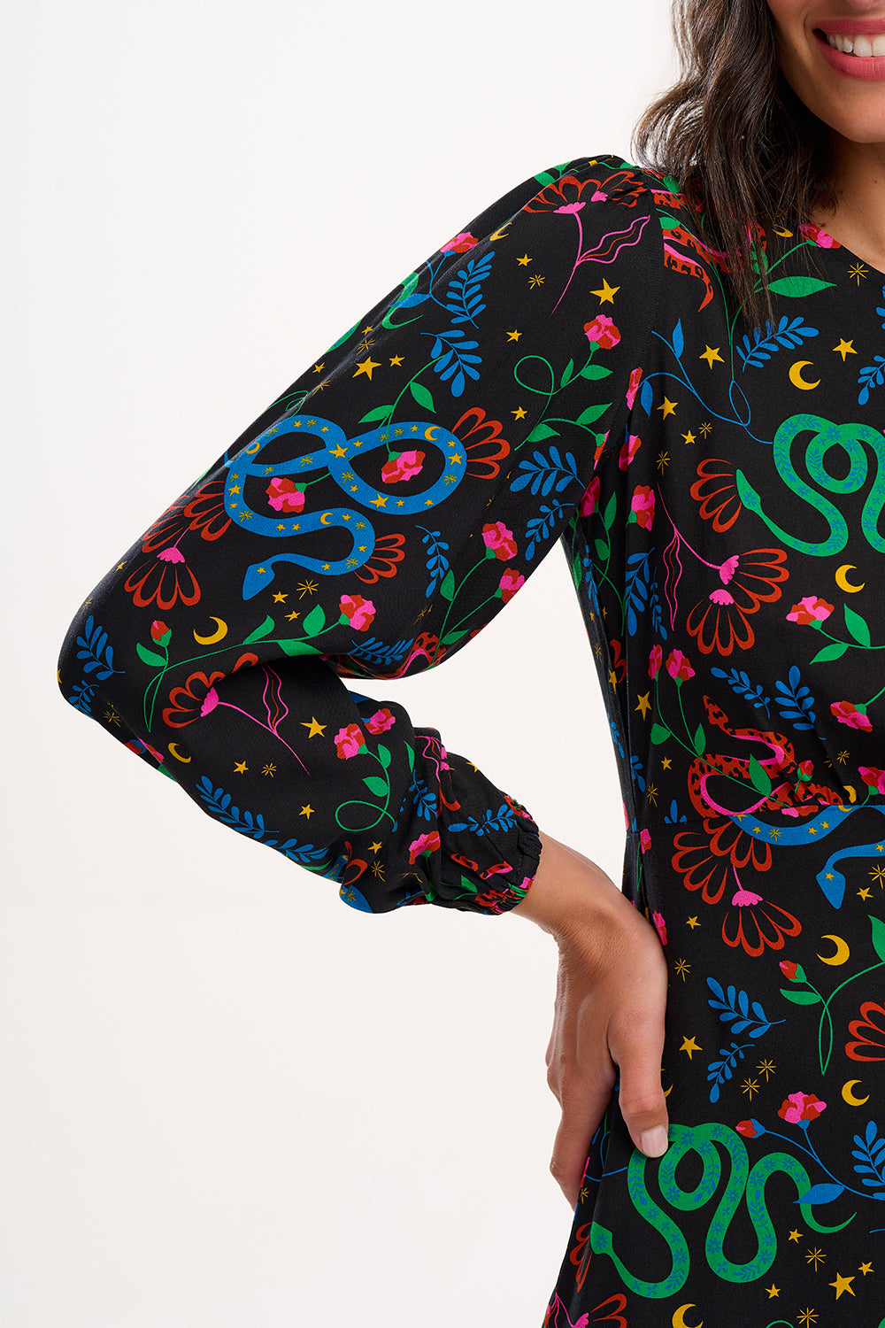 Colourful patterned dress with long sleeves on a plain background