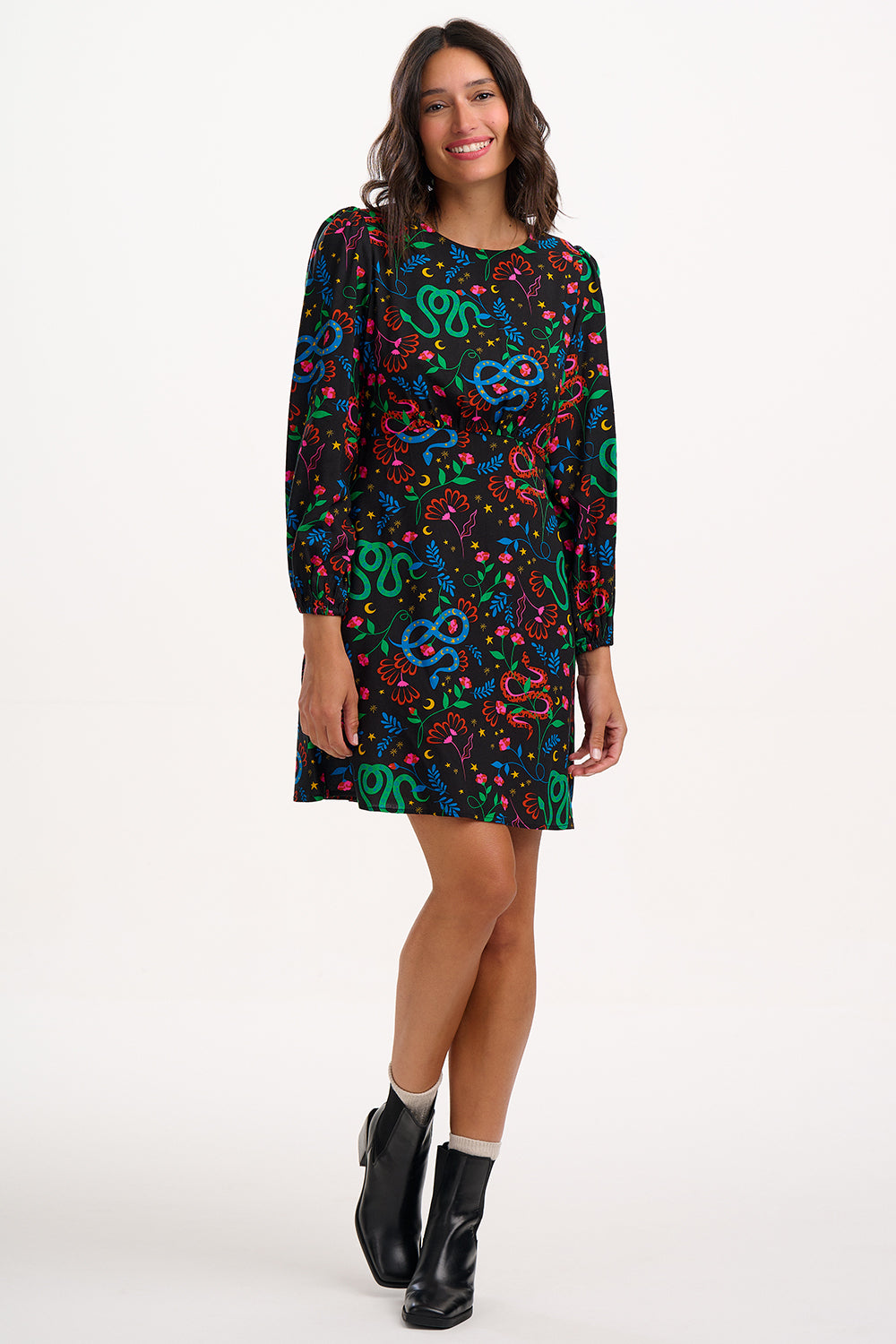 Woman wearing a colorful patterned dress on a white background