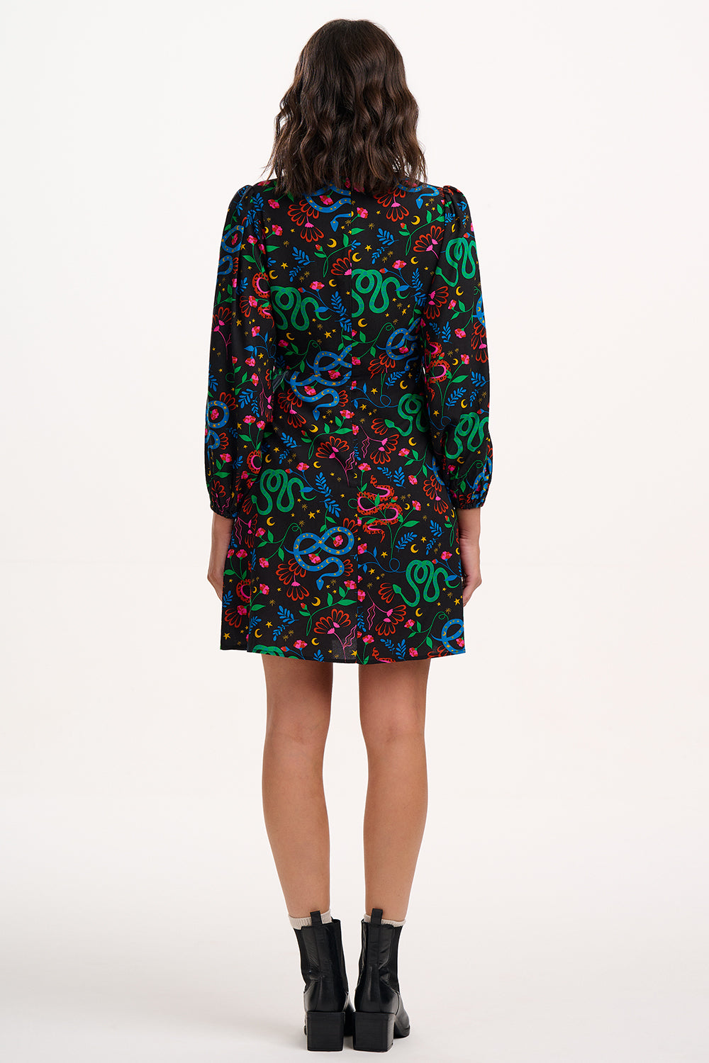 Person wearing a colorful snake pattern dress on a white background