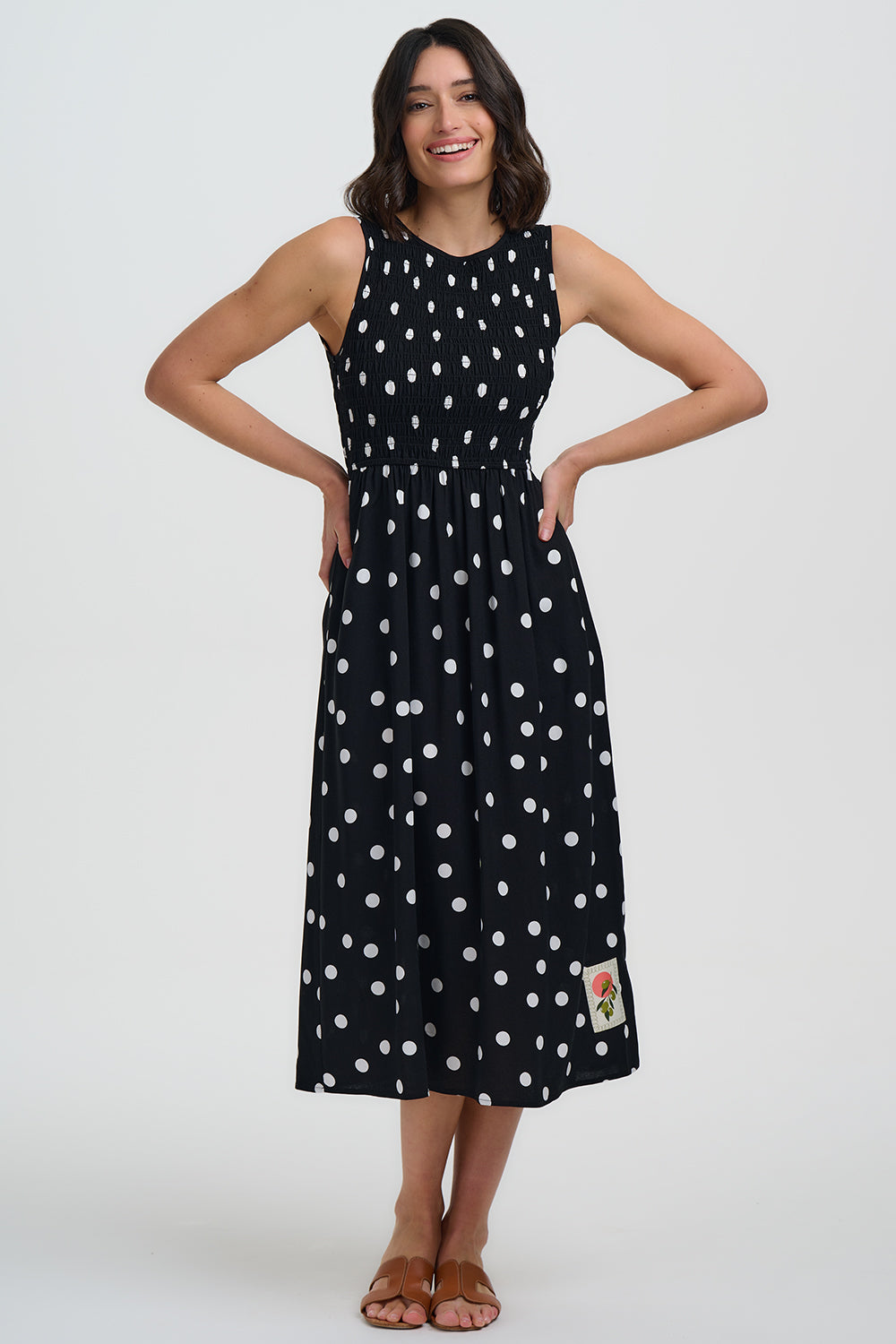 Woman wearing a black dress with white polka dots on a white background