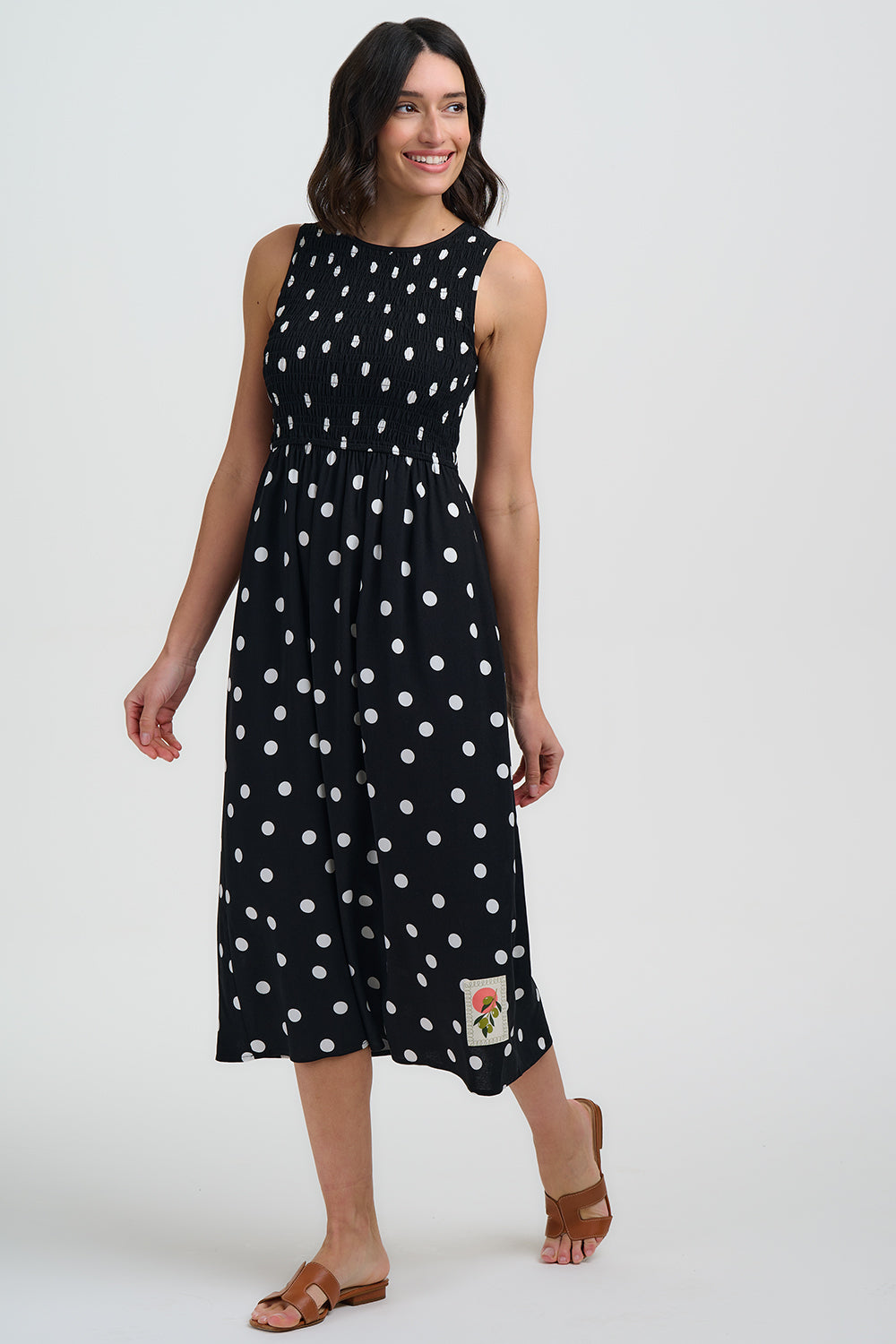 Woman wearing a black dress with white polka dots on a white background