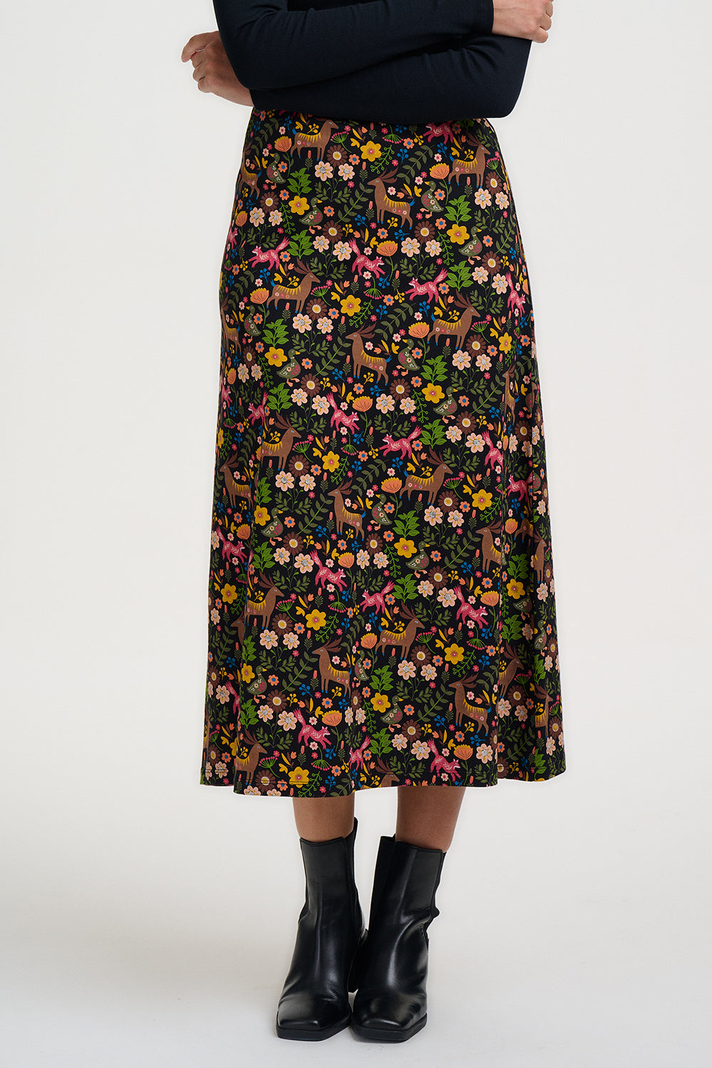 Person wearing a floral and dog patterned skirt on a white background