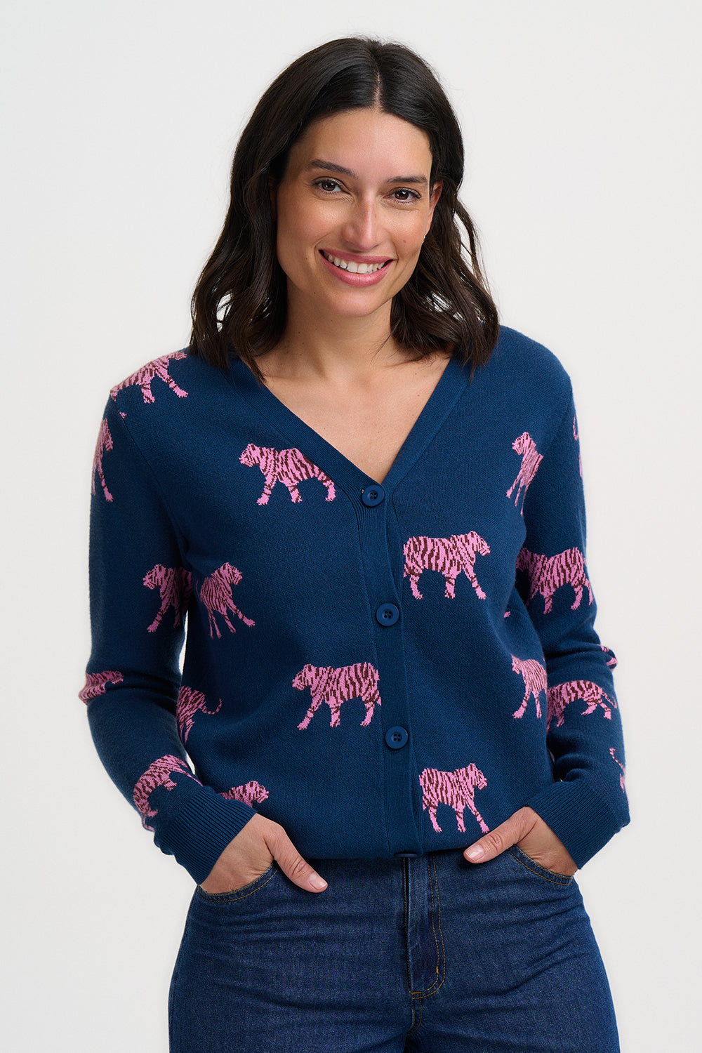 Woman wearing a navy blue cardigan with pink tiger pattern on a white background