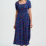 Woman wearing a blue dress with colorful patterns on a white background