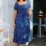 Woman wearing a blue dress with colorful patterns