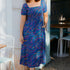 Woman wearing a blue dress with colorful patterns