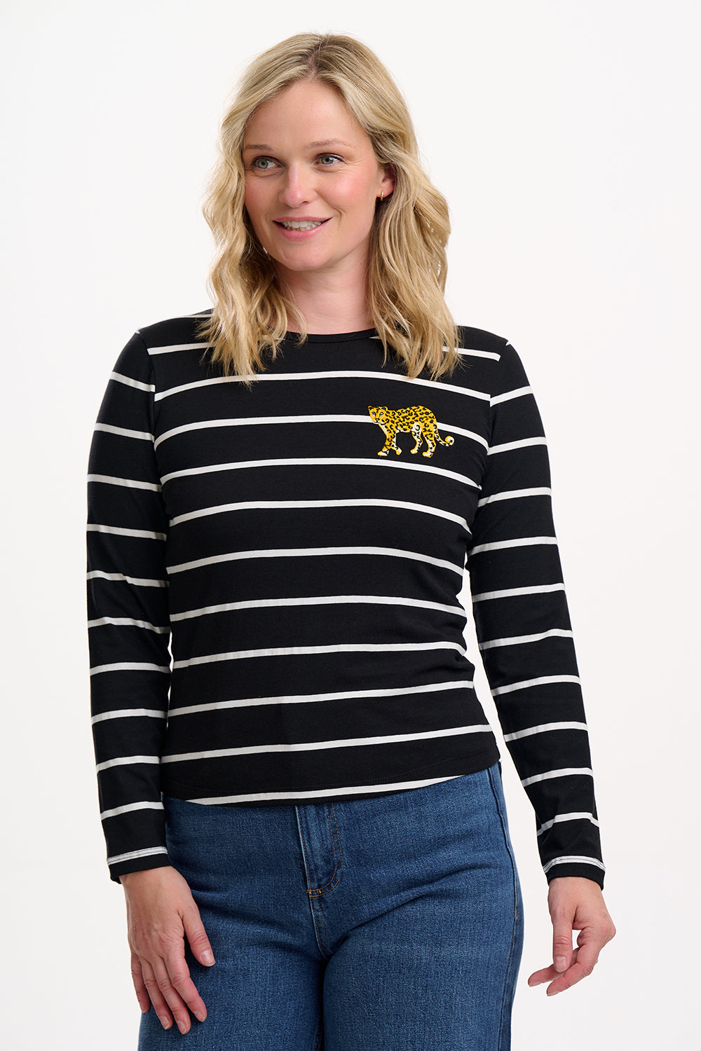 Sugarhill Brighton model wearing a black and white striped sweater with a small yellow design on a white background
