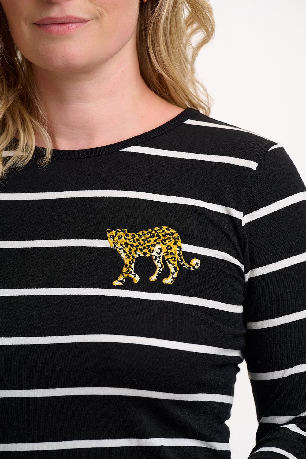 Black and white striped shirt with a leopard design on a plain background