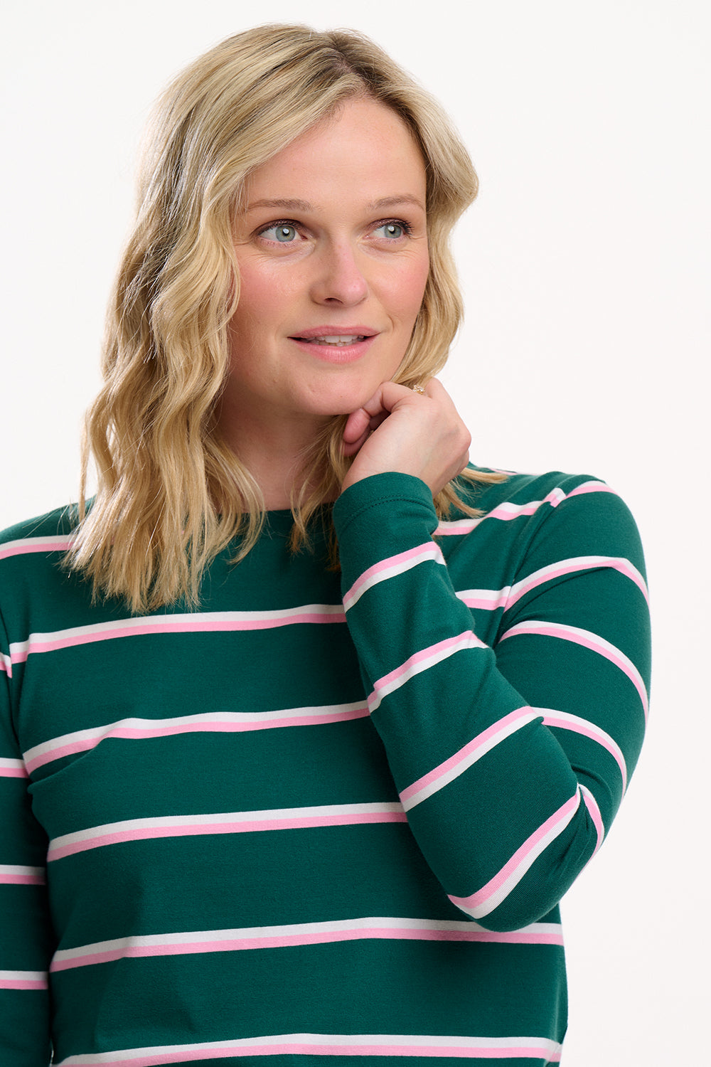 Sugarhill Brighton model wearing a green and pink striped sweater on a white background