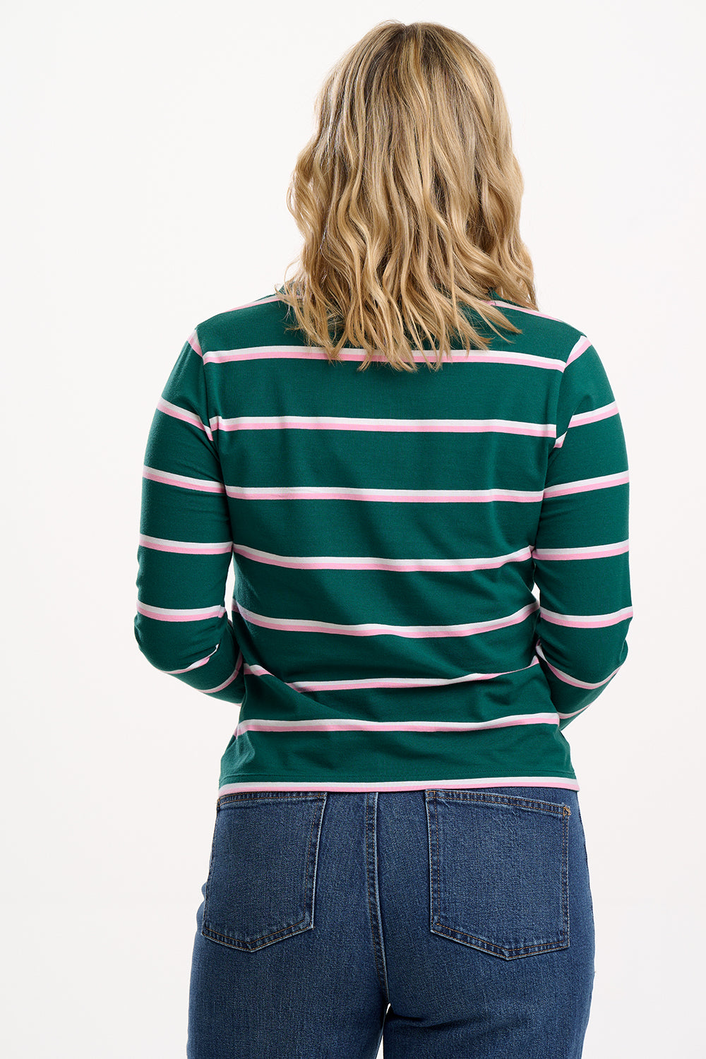 Person wearing a green and pink striped shirt with blue jeans on a white background