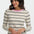 Woman wearing a striped sweater with a pink neckline on a white background