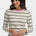Woman wearing a striped sweater with a pink neckline on a white background