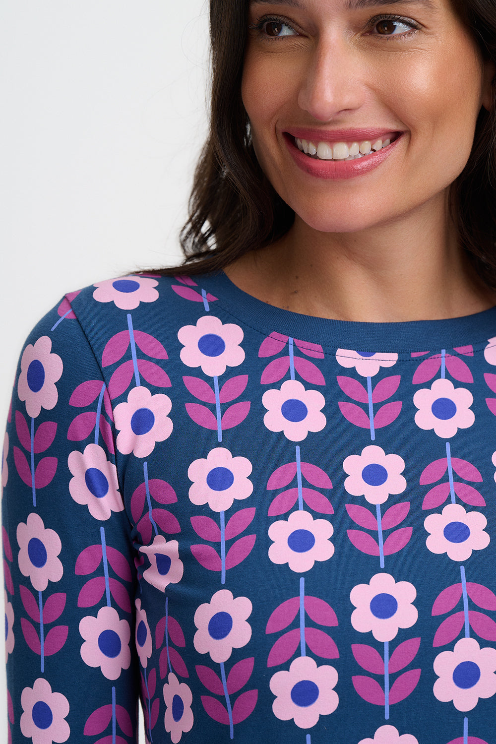 Woman wearing a blue dress with pink floral pattern on a white background