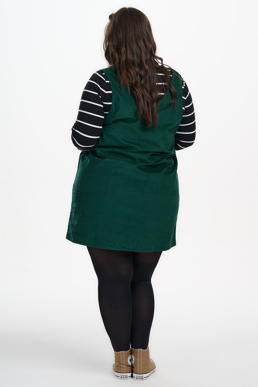 Person wearing a green apron over a striped shirt on a white background