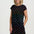 Woman wearing a black dress with colorful dinosaur pattern on a white background