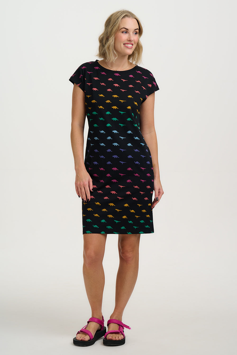 Woman wearing a black dress with colorful fish pattern on a white background