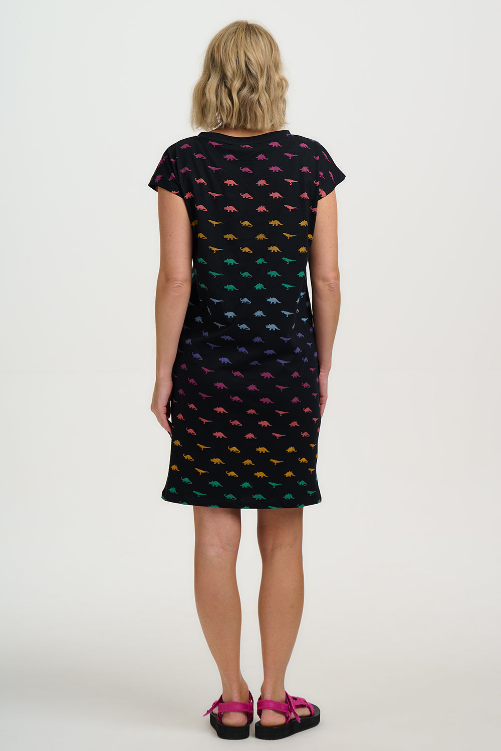 Woman wearing a black dress with colorful fish pattern on a white background