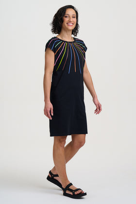 Woman wearing a black dress with a colorful pattern on a white background