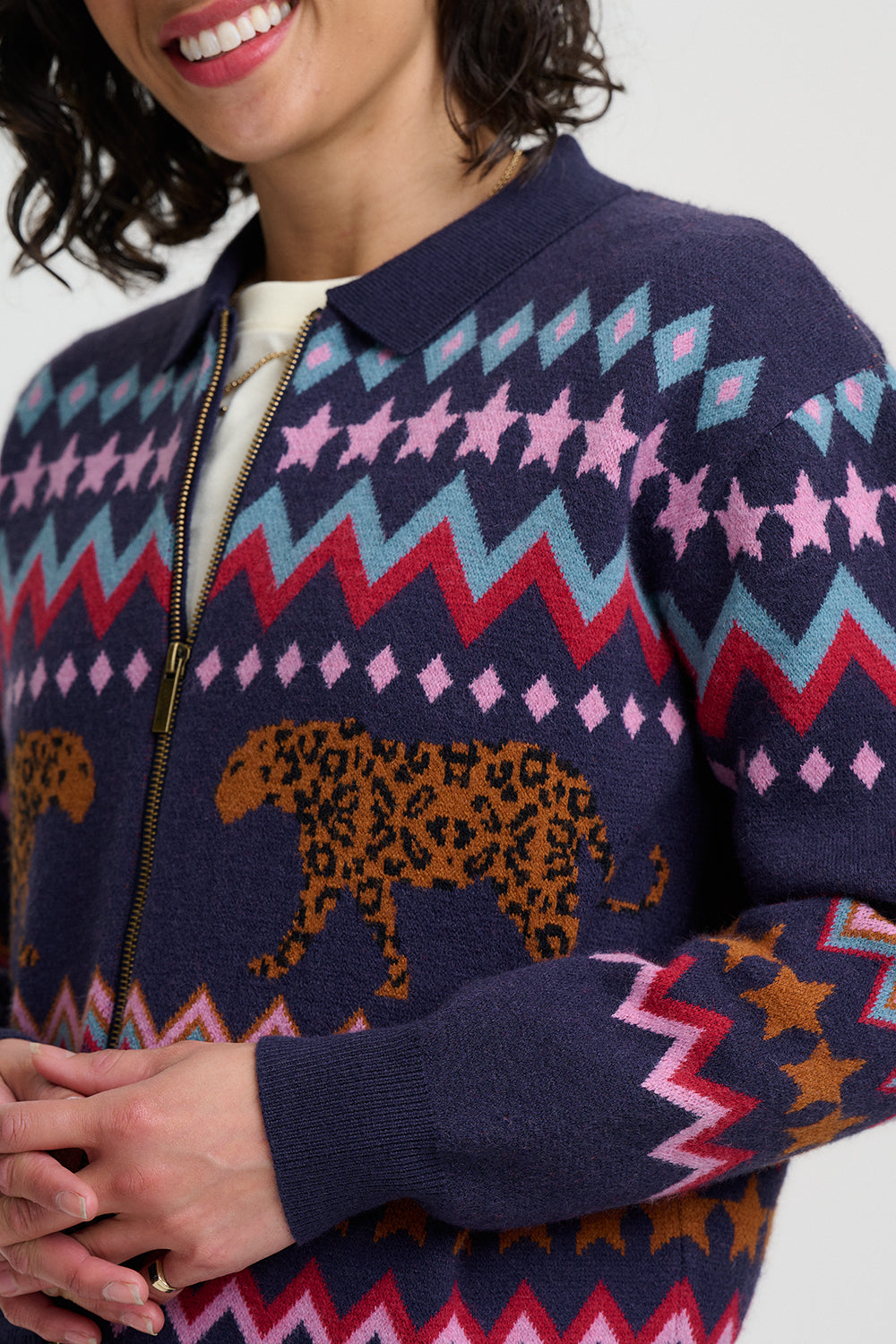 Person wearing a patterned sweater with a leopard design on a white background
