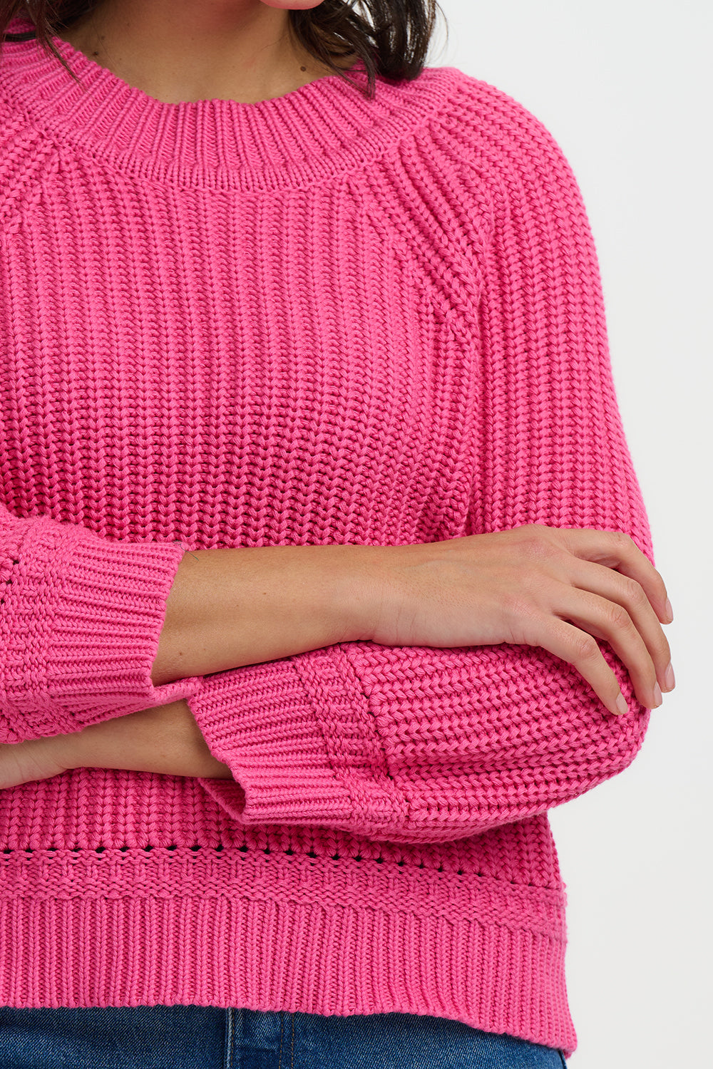 Close-up of a bright pink knitted sweater on a white background