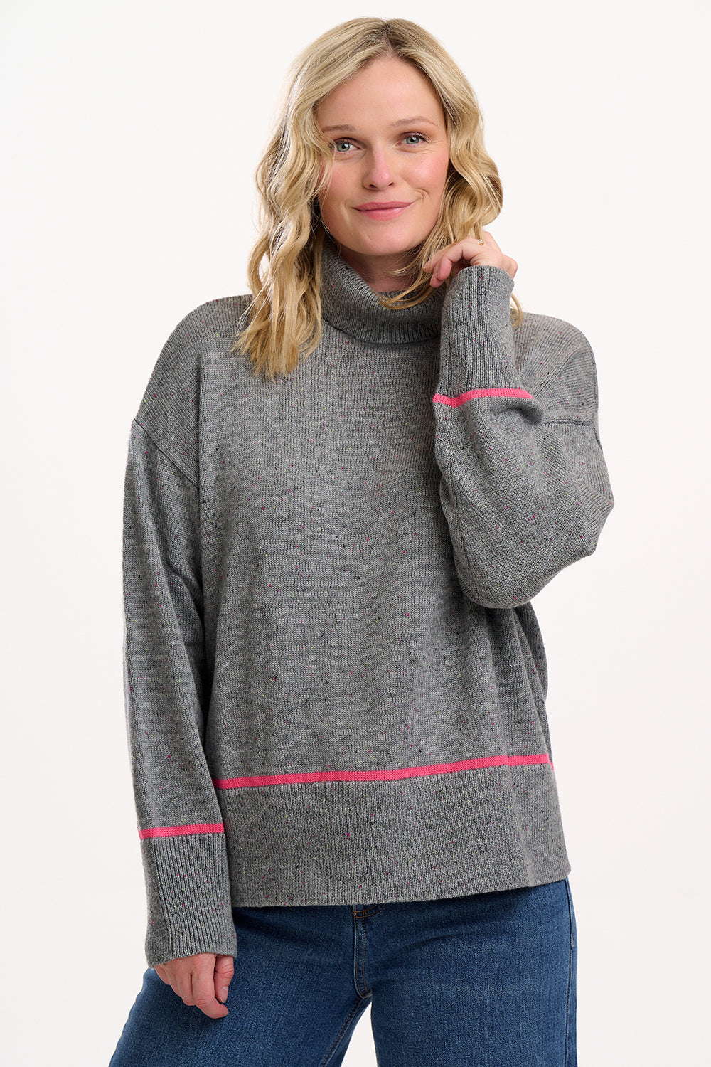 Woman wearing a gray sweater with pink accents on a white background