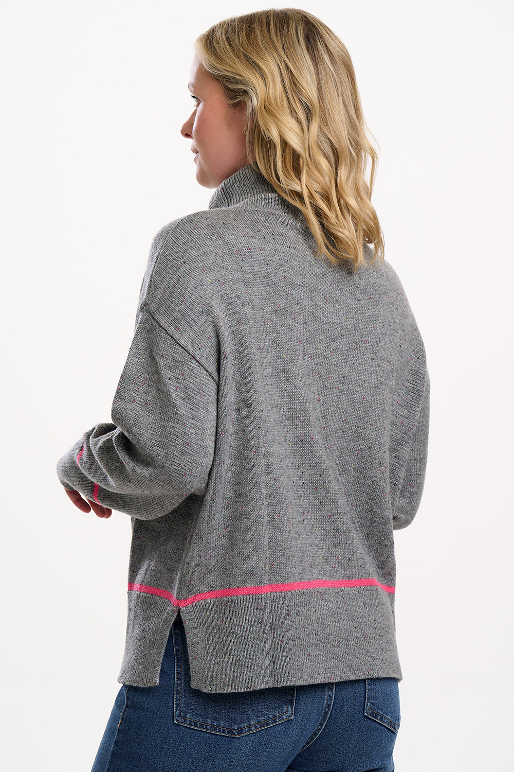 Woman wearing a gray jacket with pink accents on a white background