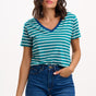 Sugarhill Brighton model wearing a green and white striped shirt with blue jeans on a white background