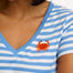 A striped V-neck t-shirt in pastel blue and white, with a small graphic of a crab on the front.
