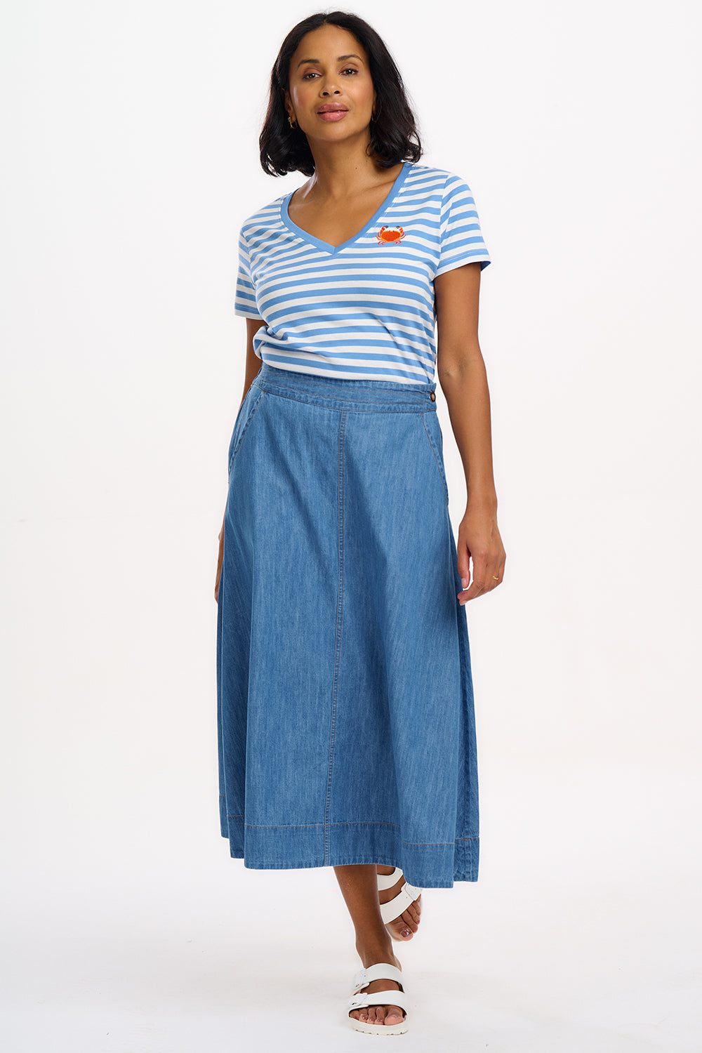 A striped V-neck t-shirt in pastel blue and white, with a small graphic of a crab on the front.