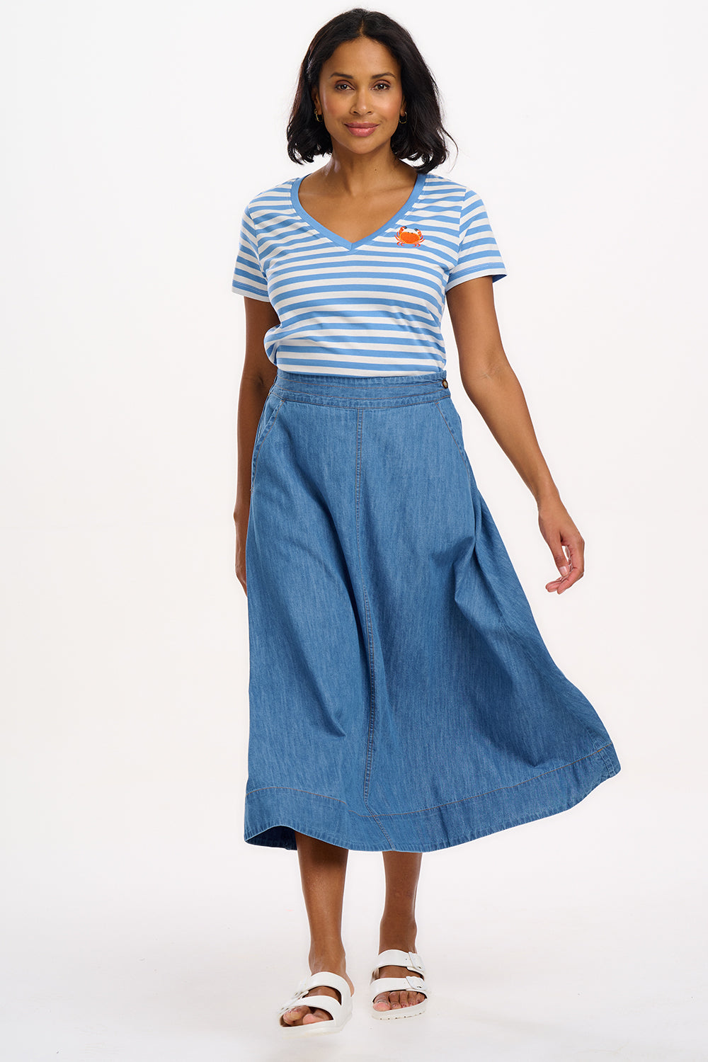 A striped V-neck t-shirt in pastel blue and white, with a small graphic of a crab on the front.
