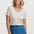 Woman wearing a colorful striped shirt and blue skirt on a white background