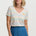Woman wearing a colorful striped shirt and blue skirt on a white background