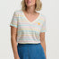 Woman wearing a colorful striped shirt and blue skirt on a white background