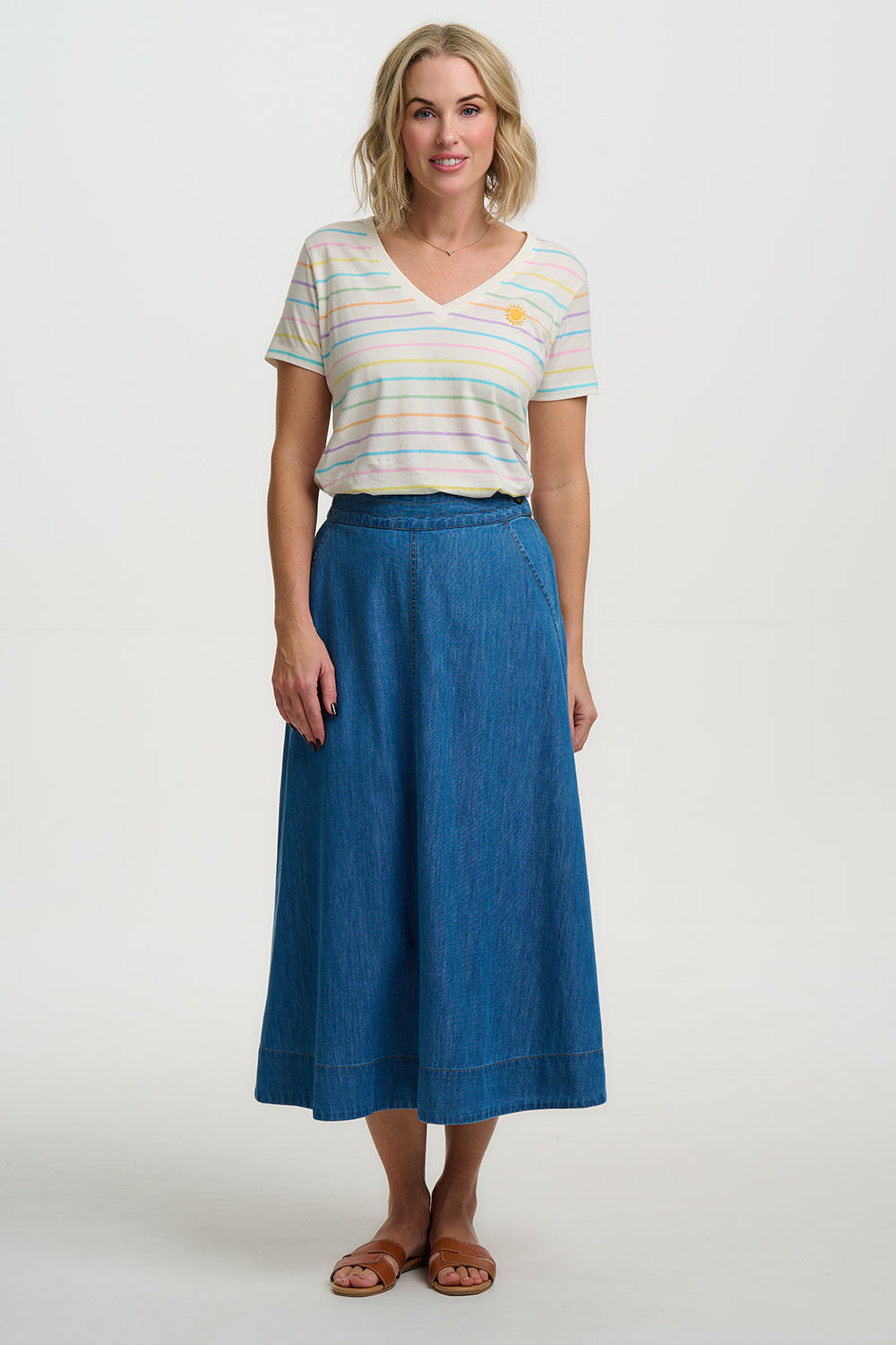Woman wearing a striped shirt and blue skirt on a white background