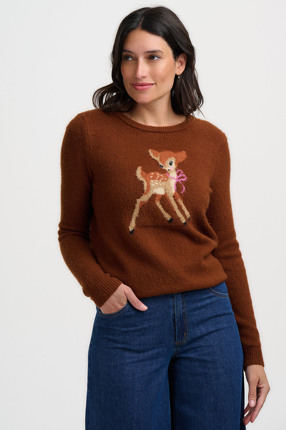Woman wearing a brown sweater with a deer design on a white background