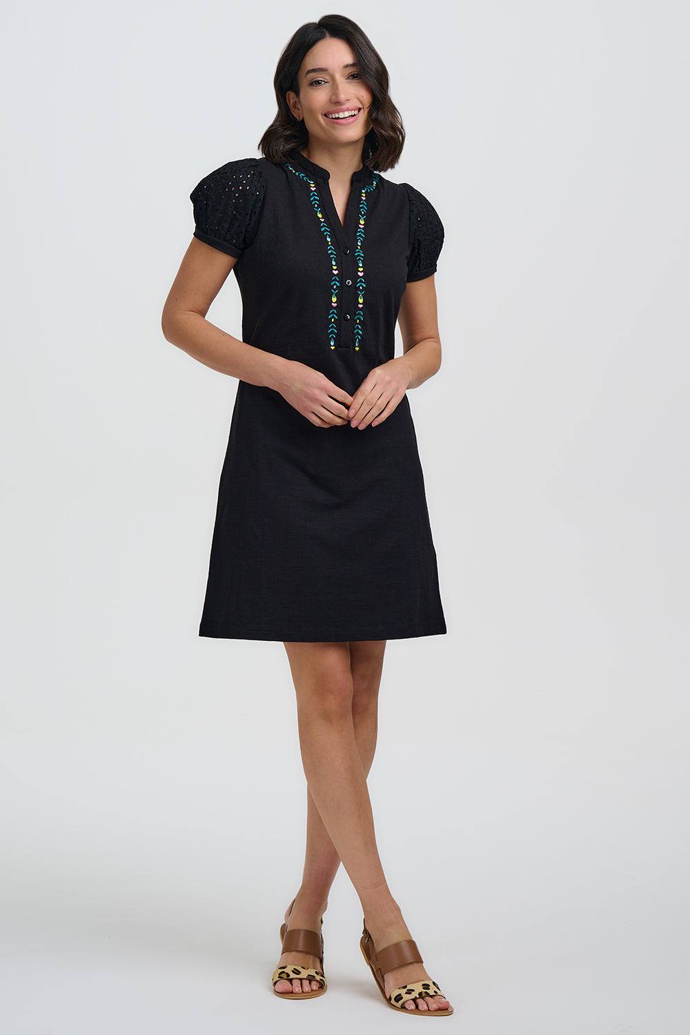 Woman wearing a black dress with embroidery on a white background