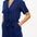 A navy playsuit with thin rainbow stripes, featuring a V-neck shirt collar, button-down front, and a tie belt.