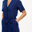 A navy playsuit with thin rainbow stripes, featuring a V-neck shirt collar, button-down front, and a tie belt.