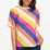 A model wearing a multicolored striped relaxed fit t-shirt with short sleeves and a round neckline.