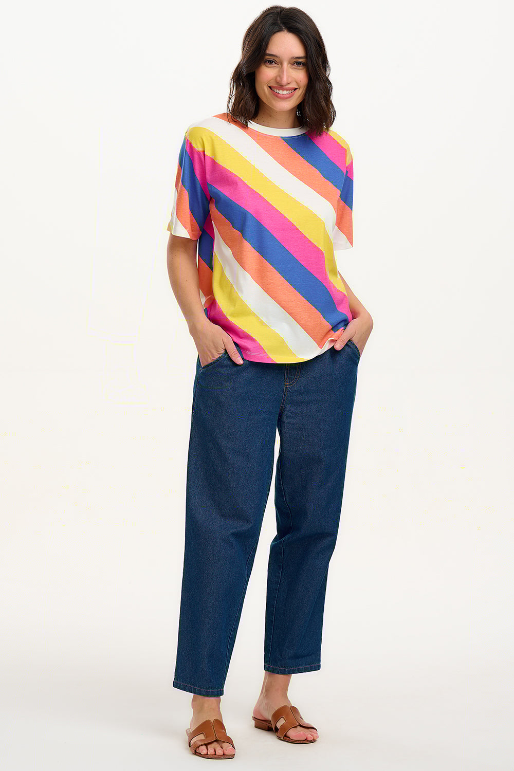 A model wearing a multicolored striped relaxed fit t-shirt with short sleeves and a round neckline.